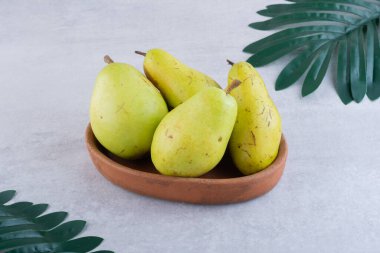 Gri arka planda taze olgun armutlar