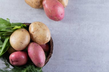 Gri arka planda taze organik patates 