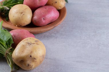 Gri arka planda taze organik patates 