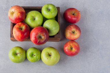 Gri arkaplanda taze olgun elmalar.
