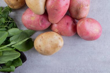 Gri arka planda taze organik patates 