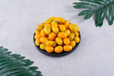 Mutfak masasında taze kumkat meyveleri. Metin için boş alan.