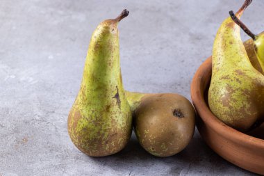 Gri arka planda taze olgun armutlar