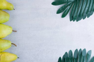 Mutfak masasında taze armut ve yapraklar. Metin için boş alan.