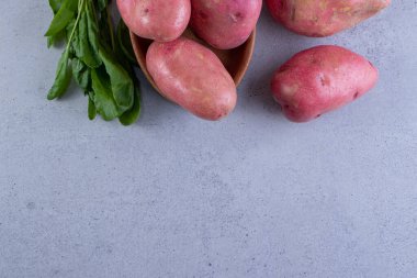 Gri arka planda taze organik patates 