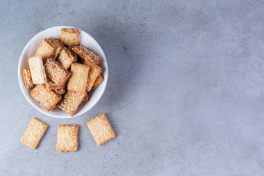 homemade crackers with sesame seeds on a dark background. copy space.