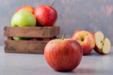 Gri arkaplanda taze olgun elmalar.