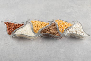 Gri arka planda kaselerde farklı Groats türleri