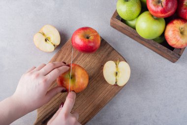 Kadın mutfak masasında taze elma kesiyor. Metin için boş alan. 