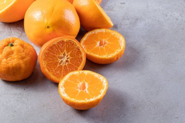 Gri bir masada taze taze portakallar 