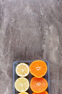 Koyu arkaplanda taze portakal ve limon dilimleri. en üstteki görünüm.