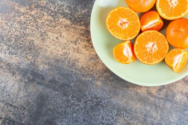 Gri bir masada taze taze portakallar 