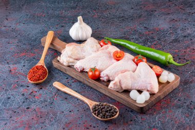 Gri masada baharatlı ve sebzeli çiğ tavuk. 