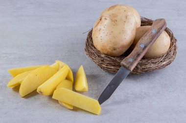 Mutfak masasında çiğ patates ve bıçak. 