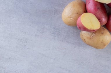 Gri arka planda taze organik patates 