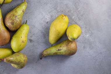 Gri arka planda taze olgun armutlar