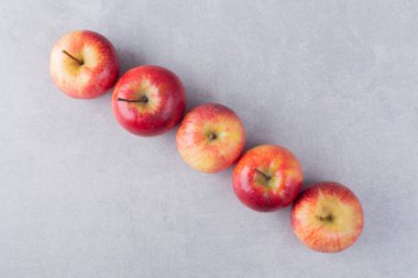 Gri arkaplanda taze olgun elmalar