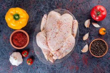 Gri masada baharatlı ve sebzeli çiğ tavuk. 