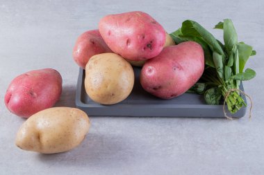 Gri arka planda taze organik patates 