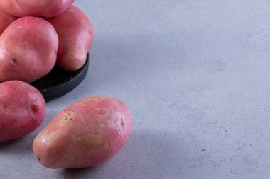 Gri arka planda taze organik patates 