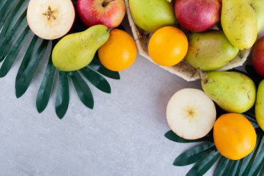 Gri arka planda çeşitli meyveler.