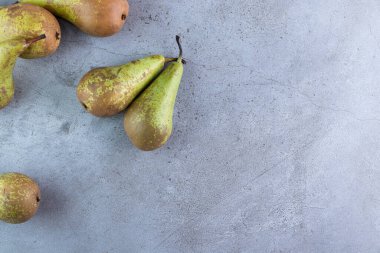 Gri arka planda taze olgun armutlar