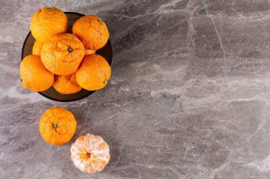 Gri masa arkaplanındaki taze portakallar