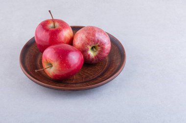 Gri arkaplanda taze olgun elmalar.