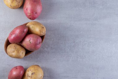 Gri arka planda taze organik patates 