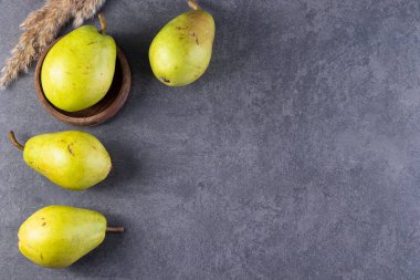 Gri arka planda taze olgun armutlar