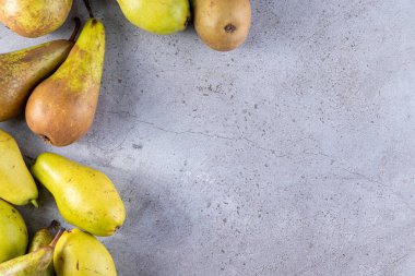 Gri arka planda taze olgun armutlar