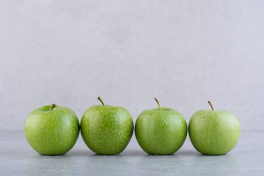 Gri arkaplanda yeşil elmalar