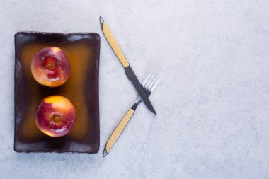 Gri arka planda çatal ve bıçaklı fırınlanmış elmalar