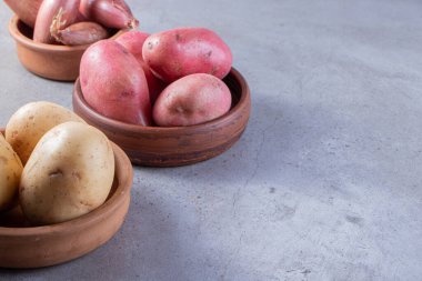 Gri arka planda taze organik patates 