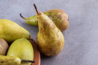 Gri arka planda taze olgun armutlar