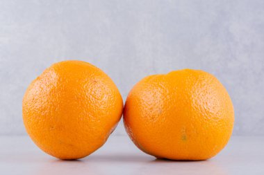 Gri mutfak masasında taze portakallar.