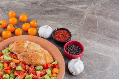 Mutfak masasında sebze ve baharatlı ızgara tavuk eti. 