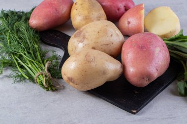 Gri arka planda taze organik patates 