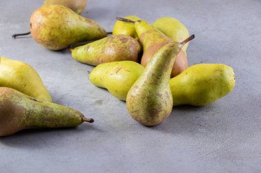 Gri arka planda taze olgun armutlar