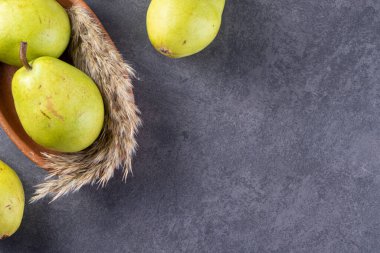 Gri arka planda taze olgun armutlar