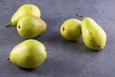 Gri arka planda taze olgun armutlar