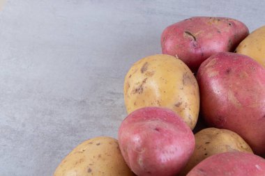 Gri arka planda taze organik patates 