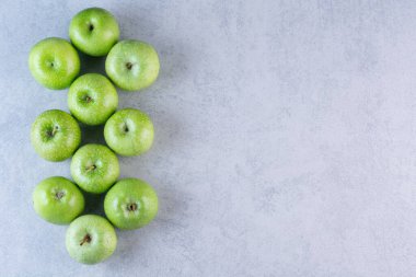 Gri arka planda yeşil elmalar. en üstteki görünüm.