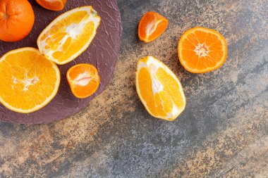 Gri bir masada taze taze portakallar 