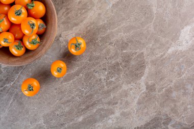Gri bir zemin üzerinde taze portakal ve sarı kiraz / domates. Üst Manzara. Boşluğu kopyala.