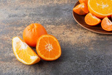 Gri bir masada taze taze portakallar 