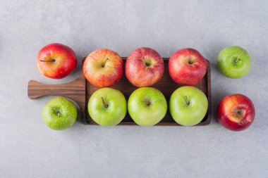 Gri arkaplanda taze olgun elmalar.