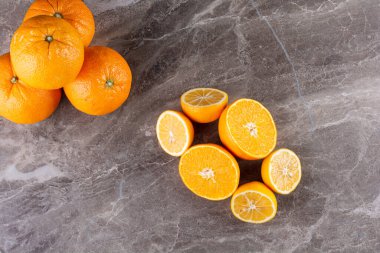 Gri masa arkaplanındaki taze portakallar