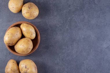 Gri arka planda taze organik patates 