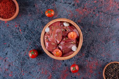 raw chicken kidneys with ingredients for cooking  on kitchen table